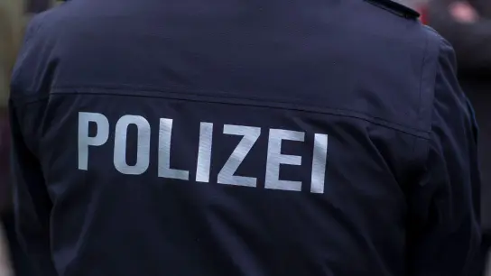 „Polizei“ steht auf der Uniform eines Polizisten. (Foto: Jens Büttner/zb/dpa/Symbolbild)