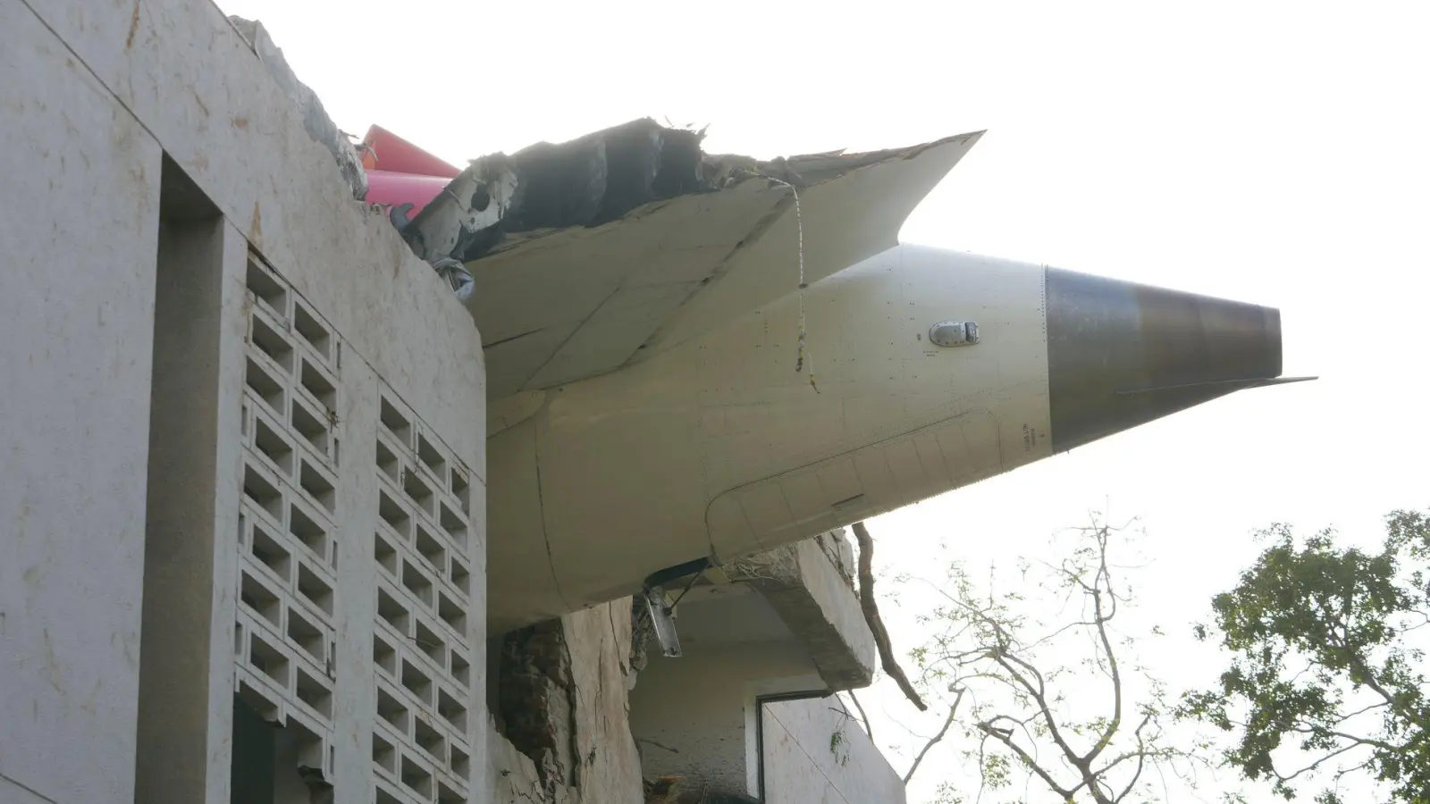 Trümmer der Boeing 787-8 Dreamliner ragen aus einem Gebäude.  (Foto: Ajit Solanki/AP/dpa)