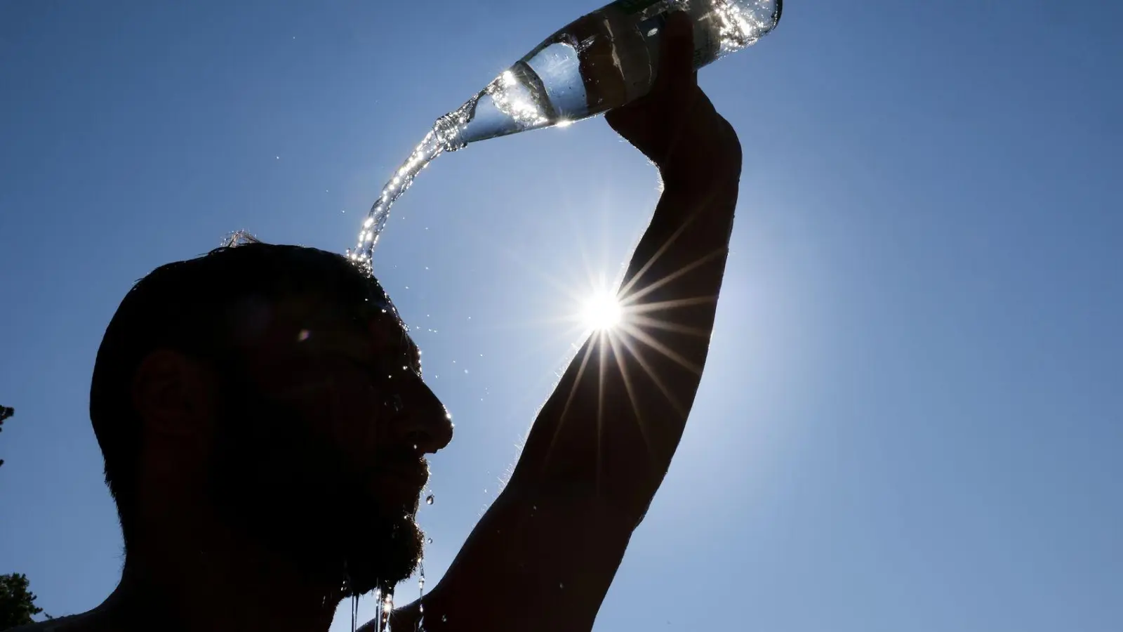 Ein Mann kühlt sich bei Hitze ab. (Archivbild) (Foto: Thomas Warnack/dpa)