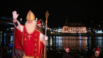 Von zahlreichen Fackelschwimmern begleitet ist der Nikolaus in Bernkastel-Kues in einem Ruderboot über die Mosel gekommen. (Foto: Harald Tittel/dpa)