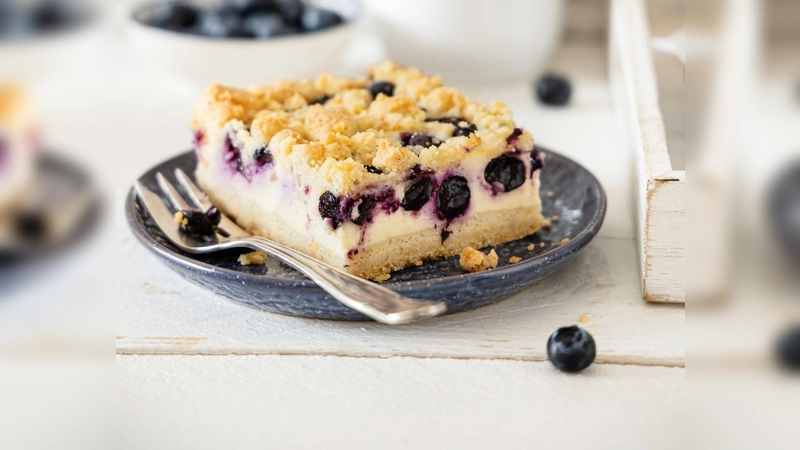 Streusel und Blaubeeren machen den Käsekuchen knusprig und fruchtig.  (Foto: Sonja Bauer/dpa-tmn)