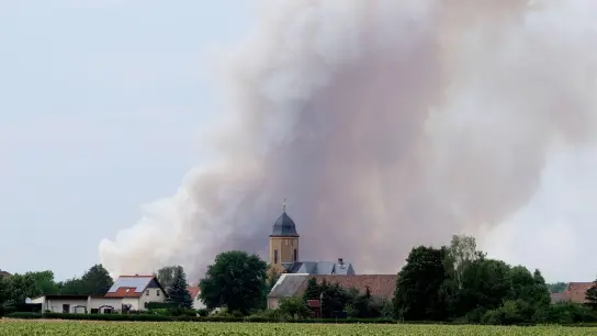 Rauch eines Waldbrandes steigt über dem Dorf Lichtensee (Landkreis Meißen) auf. Seit 23.06.2022 brennt es in der Gohrischheide. (Foto: Sebastian Willnow/dpa)