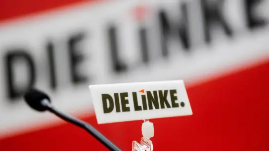 Das Logo der Partei Die Linke ist an einem Mikrophon zu sehen. (Foto: Christoph Soeder/dpa/Archivbild)