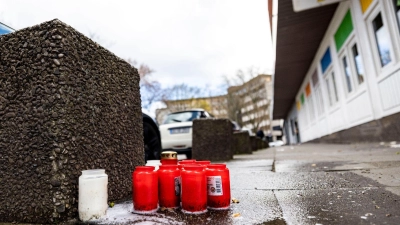 Passanten haben am Tatort Kerzen in der Duisburger Altstadt niedergelegt. (Foto: Christoph Reichwein/dpa/Archivbild)