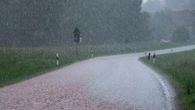 Das Regenwasser spült Erde über eine Straße. Regenwolken ziehen über Südthüringen und es regnet stark. (Foto: Daniel Vogl/dpa)