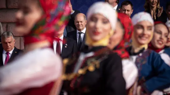 Bundeskanzler Olaf Scholz (M) beobachtet eine traditionelle Tanzvorführung beim Familienfoto beim EU-Westbalkan-Gipfel. Links ist Viktor Orban, Ministerpräsident von Ungarn, zu sehen. (Foto: Michael Kappeler/dpa)