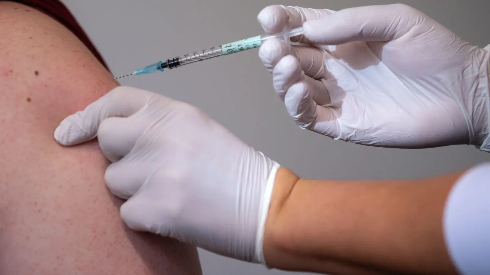 Eine Mitarbeiterin eines Impfzentrums impft einen Mann gegen Corona. (Foto: Sven Hoppe/dpa/Symbolbild)
