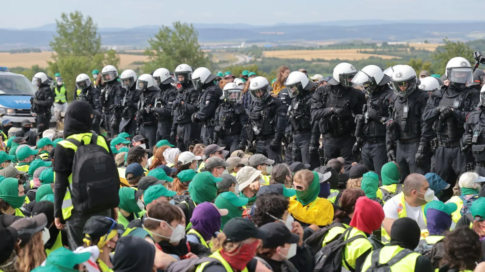 Eine Sitzblockade auf der Autobahn 71 - Polizisten umringen die Demonstranten. (Foto: Michael Reichel/dpa)
