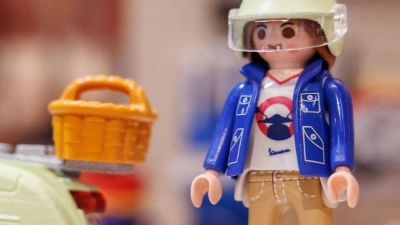 Eine Playmobil-Figur mit Vespa aus der Kidult-Reihe steht im Vorfeld der Spielwarenmesse am Stand von Playmobil. (Foto: Daniel Karmann/dpa)