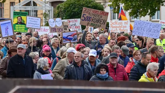 Menschen nehmen an einer Demonstration im Stadtzentrum von Frankfurt (Oder) teil - die Parolen auf den Schildern sind vielfältig. (Foto: Patrick Pleul/dpa)