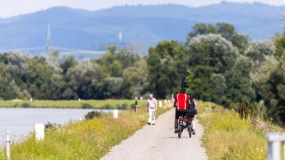 Zwei Radfahrer fahren neben dem Rhein auf einem Weg entlang. (Foto: Philipp von Ditfurth/dpa)