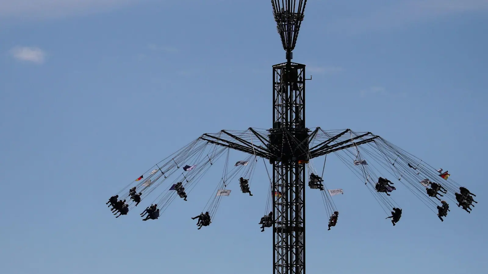 Besucher des Nürnberger Frühlingsfestes sitzen in einem Fahrgeschäft. (Foto: Daniel Karmann/dpa)