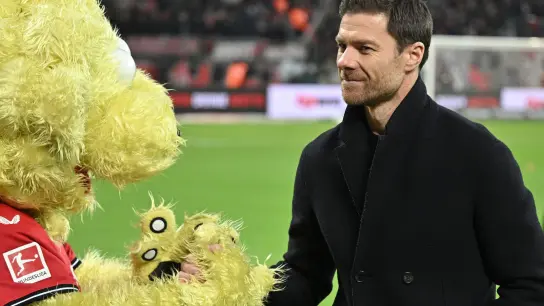 Leverkusens Trainer Xabi Alonso ist von Leverkusens Maskottchen Brian the Lion begrüßt. (Foto: Bernd Thissen/dpa/Archivbild)