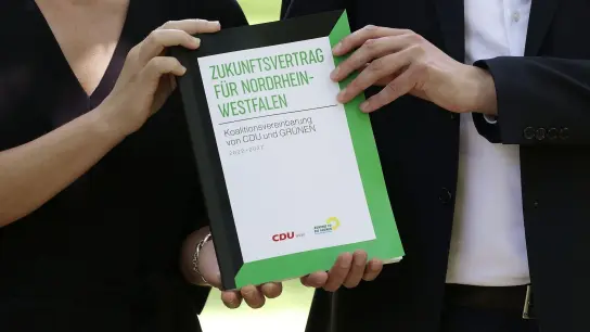 Ministerpräsident Hendrik Wüst (r.) und die Grünen-Vorsitzende Mona Neubaur stellen den Koalitionsvertrag von Schwarz-Grün in NRW vor. (Foto: David Young/dpa)