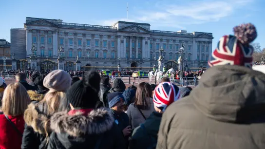 Touristen beobachten die Wachablösung vor dem Buckingham-Palast. Einer Umfrage zufolge sind 2022 bis Ende des Sommers 83 Prozent weniger Schülerinnen und Schüler aus Europa nach Großbritannien gereist als noch 2019. (Foto: Dominic Lipinski/PA Wire/dpa)