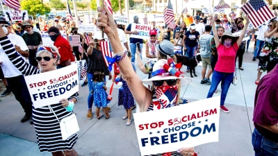 Der „Sozialismus“-Vorwurf ist beliebt bei Anhängern der extremen Rechten in den USA - hier bei einer Demonstranten gegen Corona-Maßnahmen im Jahr 2020. (Foto: Watchara Phomicinda/The Orange County Register/AP/dpa)