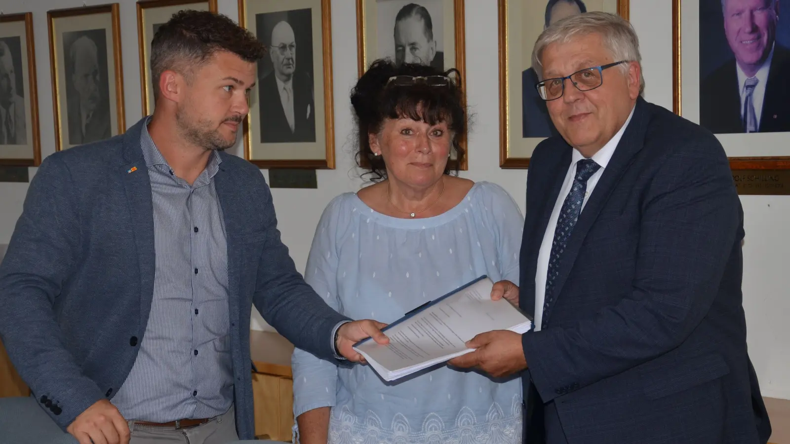 Eine Mappe mit über 700 in Dietersheim gesammelten Unterschriften gegen das dort geplante Containerdorf übergaben (von links) Thomas Billmann und Gudrun Ruttmann-Völliger an Landrat Helmut Weiß. (Foto: Patrick Lauer)
