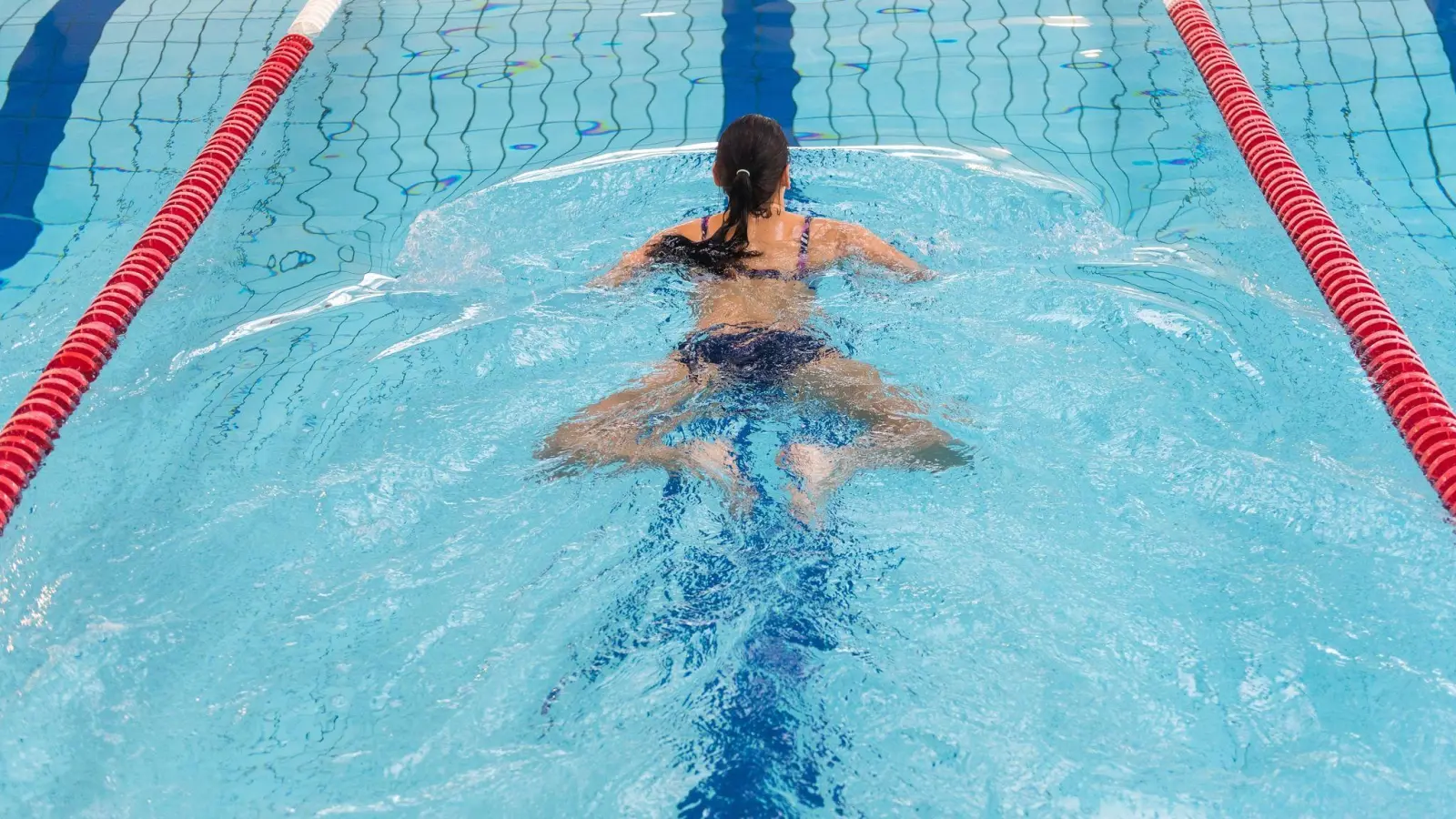 Eine Angewohnheit, die sich beim Brustschwimmen bei vielen Menschen einschleicht: Sie bewegen die Beine zeitversetzt. (Foto: Benjamin Nolte/dpa-tmn)