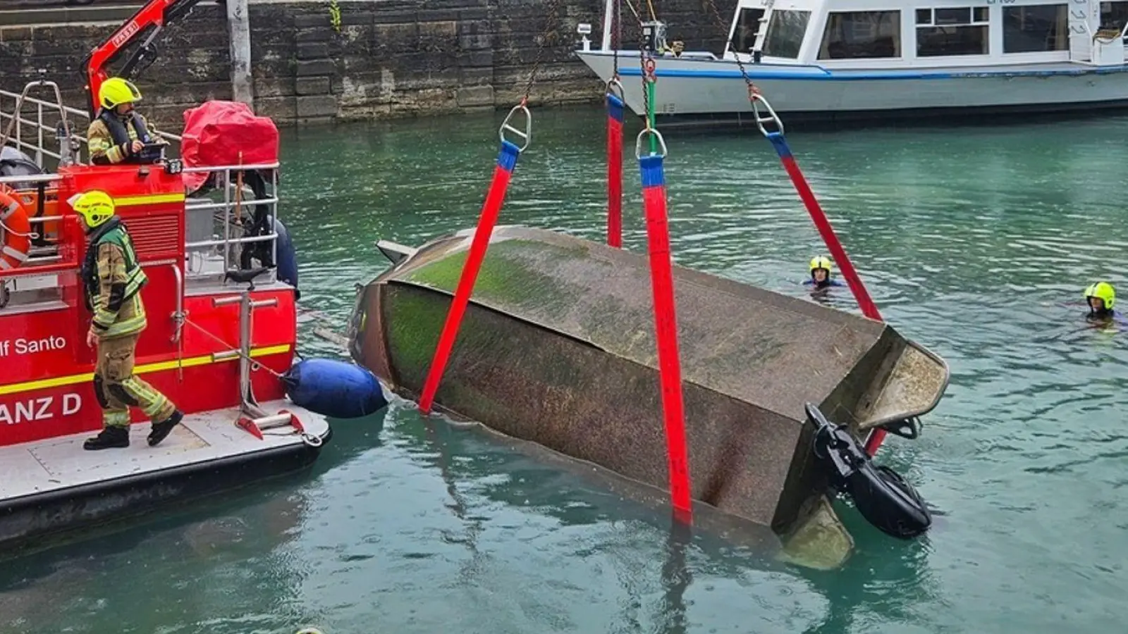 Feuerwehrleute bergen das gekenterte Motorboot.  (Foto: Handout / Berlin/Feuerwehr Konstanz/dpa)