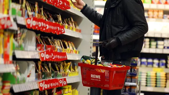 Ein Regal mit Angebotspreisen in einem Rewe-Supermarkt. (Foto: Oliver Berg/dpa)