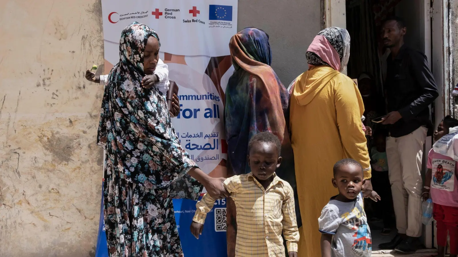 Sudanesische Flüchtlinge vor dem Gelände eines medizinischen Konvois für Neuankömmlinge in Ägypten. (Foto: Lobna Tarek/dpa)