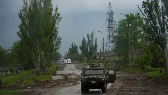 Ein russisches gepanzertes Fahrzeug bewacht die Straße zum belagerten Stahlwerk Azovstal während einer Evakuierung in Mariupol. (Foto: Alexander Zemlianichenko/AP/dpa)