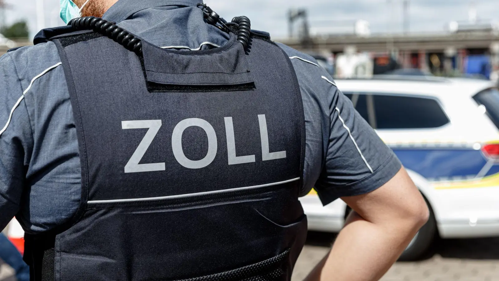 Ein Beamter trägt während seines Dienstes eine Schutzweste mit der Rückenaufschrift „Zoll”. (Foto: Markus Scholz/dpa/Symbolbild)