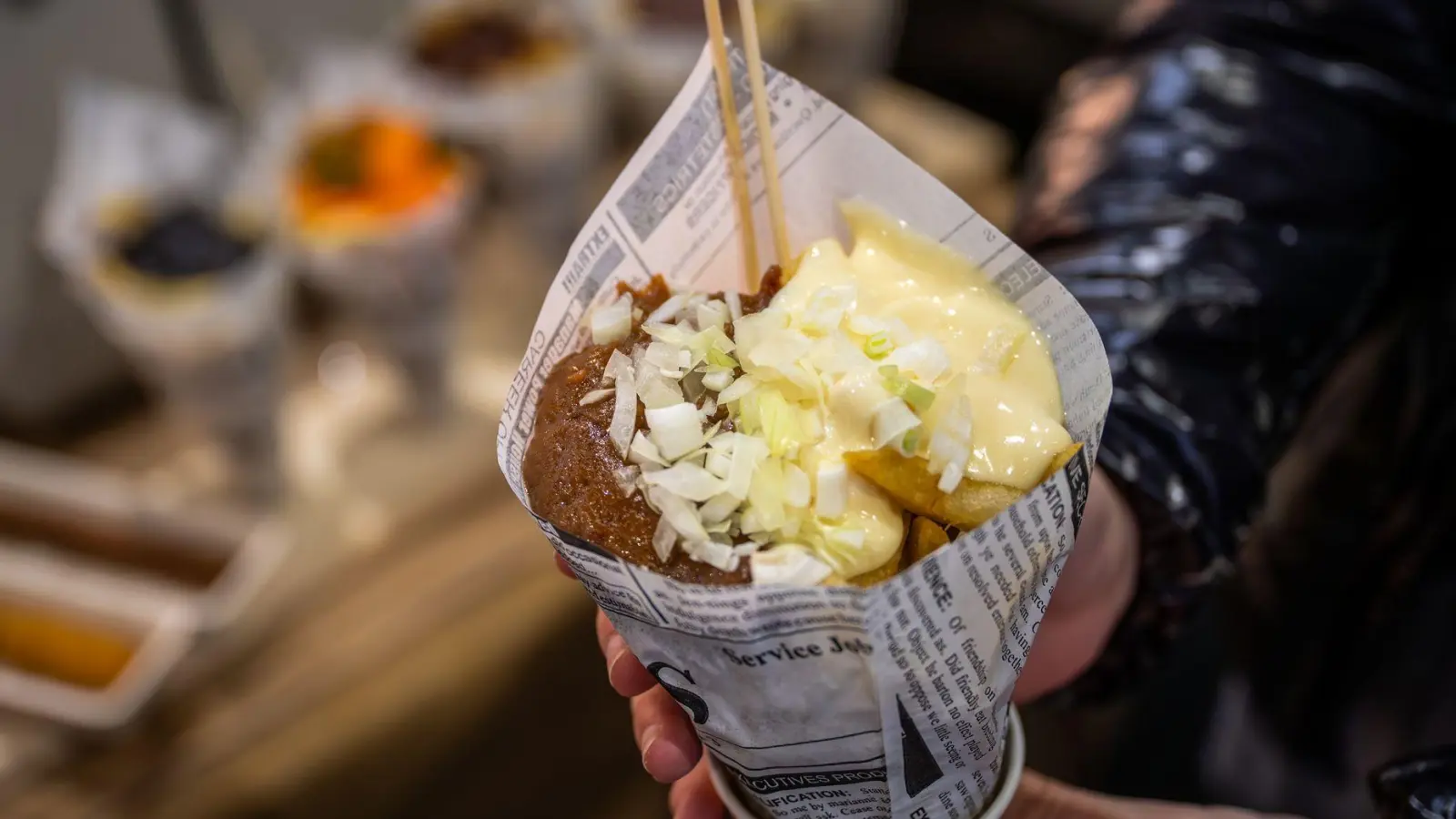 Krieg der braun-weißen Soßen: Erdnusssoße, Mayo und rohe Zwiebeln toppen die frischen Pommes.  (Foto: Nico Tapia/dpa-tmn)