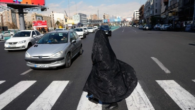Alltag in Teheran:  Verschleierte Frau überquert Kreuzung im Zentrum (Foto: Vahid Salemi/AP/dpa)