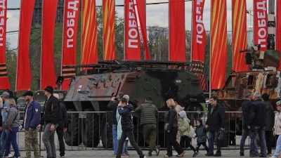 Menschen besichtigen eine Schau zu Kriegstrophäen im Park Pobedy (Park des Sieges) in Moskau. Gezeigt wird Militärtechnik aus verschiedenen westlichen Ländern und der Ukraine. Im Hintergrund zu sehen sind rote Fahnen mit der Aufschrift Pobeda! (auf Deutsch: Sieg). (Foto: Ulf Mauder/dpa)