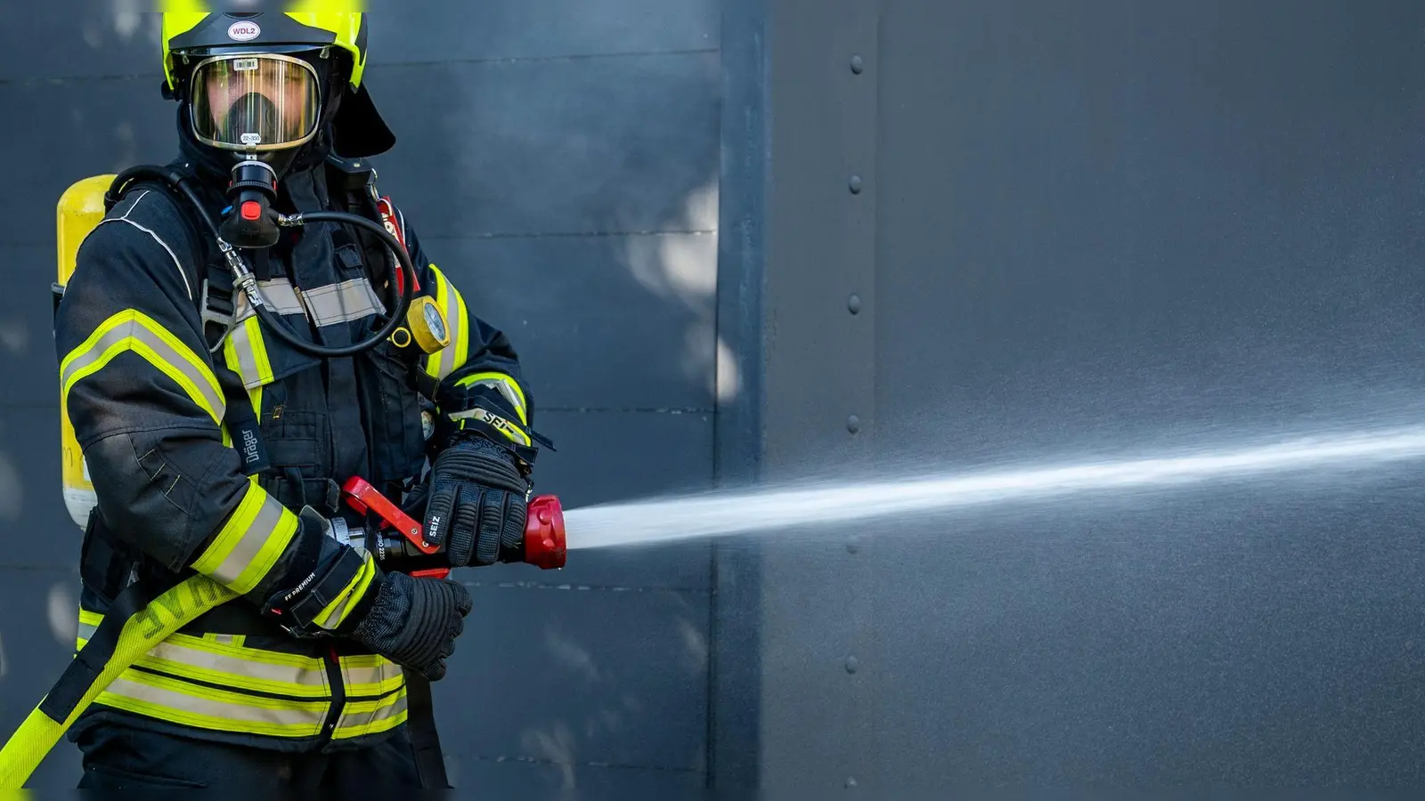Ein Mitglied der Feuerwehr beim Löscheinsatz. (Foto: David Inderlied/dpa/Symbolbild)