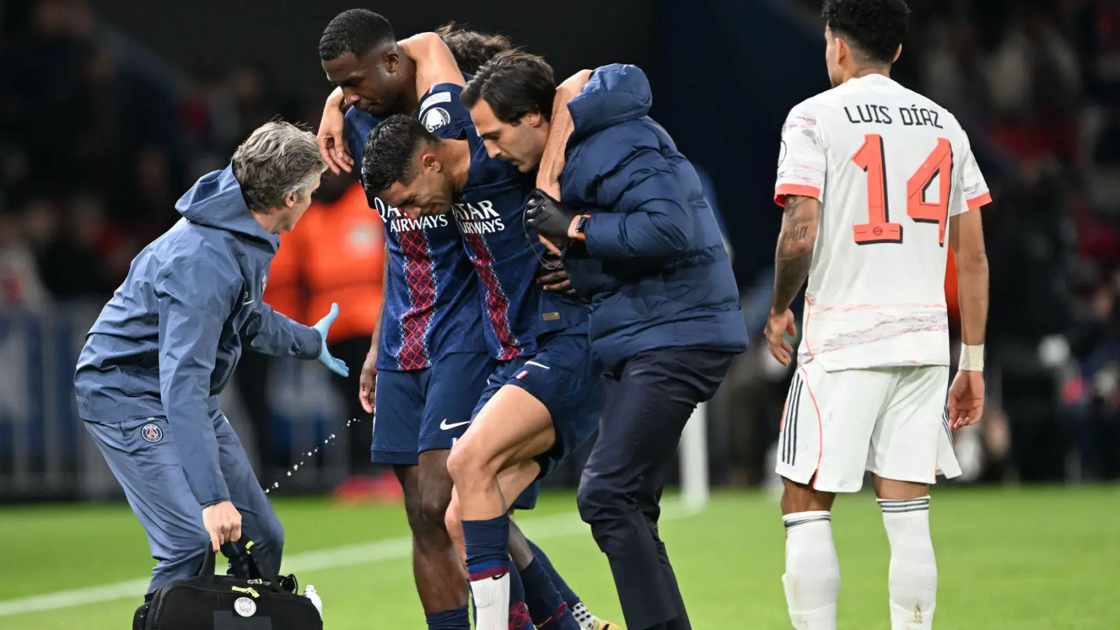 Auf Betreuer gestützt wird der am Fuß verletzte PSG-Spieler Achraf Hakimi (M) vom Platz geführt.  (Foto: Federico Gambarini/dpa)