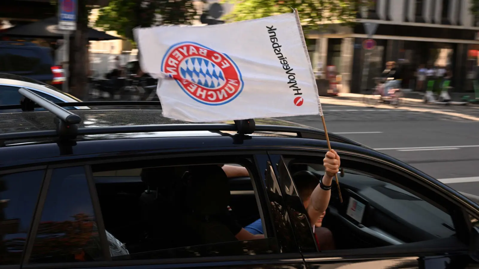 Vereinzelte Fans des FC Bayern fahren über die Leopoldstraße. (Foto: Felix Hörhager/dpa)