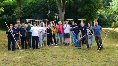 Die Berufsintegrationsklasse zeigt vollen Arbeitseinsatz, um das liegengebliebene Heu auf der Streuobstwiese an der Kobolzeller Steige aufzuräumen. (Foto: Irmeli Pohl)