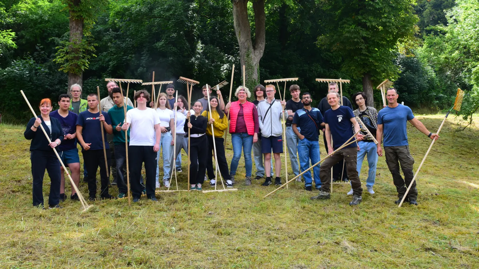 Die Berufsintegrationsklasse zeigt vollen Arbeitseinsatz, um das liegengebliebene Heu auf der Streuobstwiese an der Kobolzeller Steige aufzuräumen. (Foto: Irmeli Pohl)