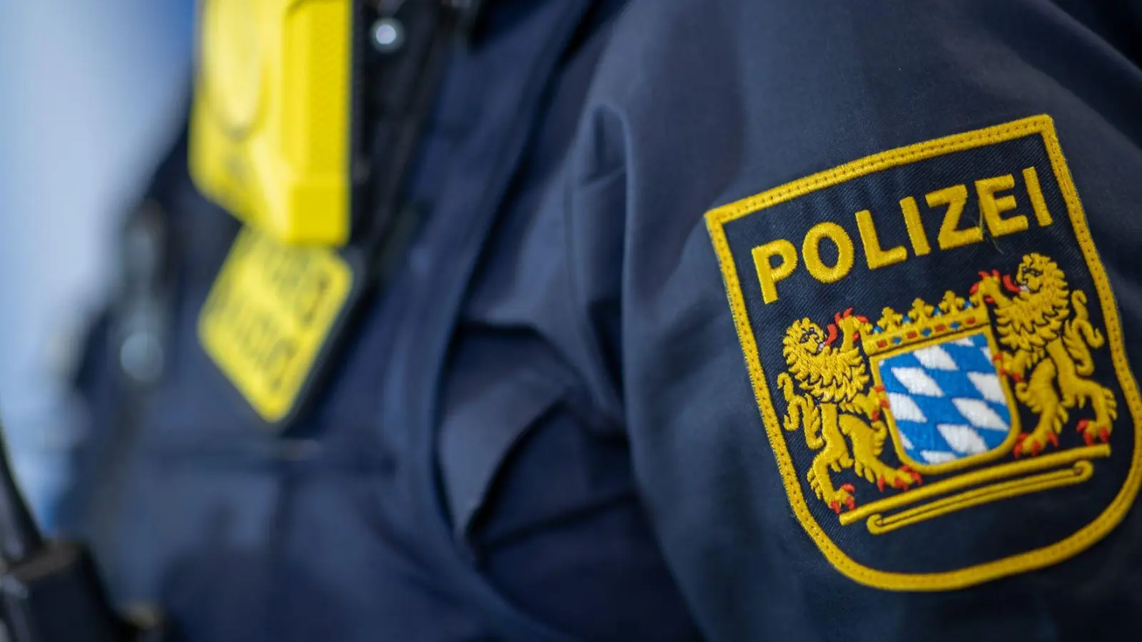 Eine Polizistin trägt ein Abzeichen der bayerischen Polizei. (Foto: Daniel Karmann/dpa/Symbolbild)