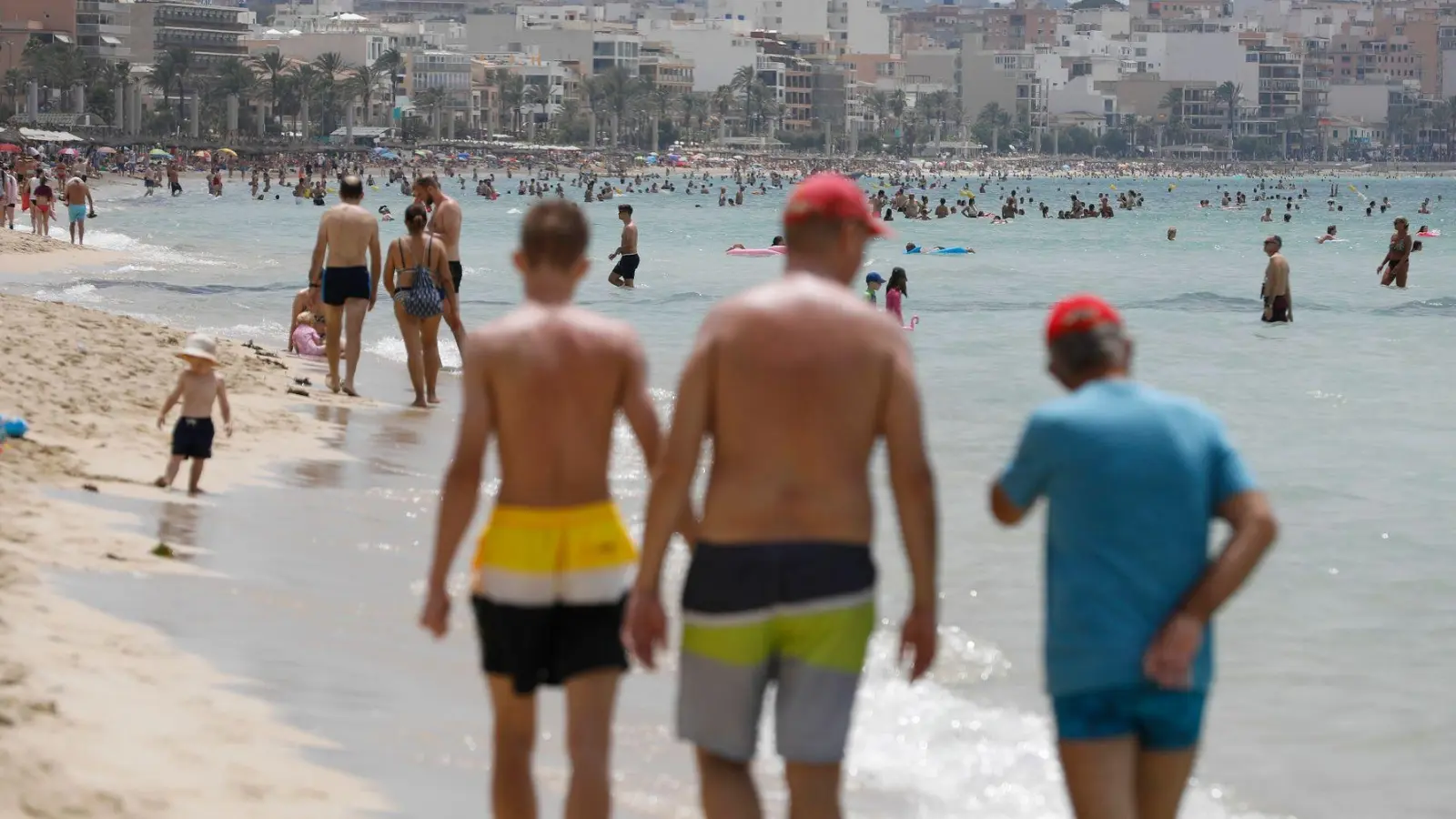 Menschen laufen am Strand von Arenal auf Mallorca. (Foto: Clara Margais/dpa)
