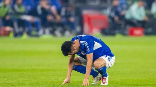 Schalkes Maya Yoshida kauert nach dem Schlusspfiff auf dem Rasen. (Foto: David Inderlied/dpa)