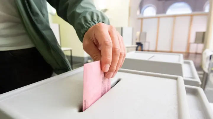 Ein Mann wirft seinen Stimmzettel in eine Urne. (Foto: Julian Stratenschulte/dpa/Symbolbild)