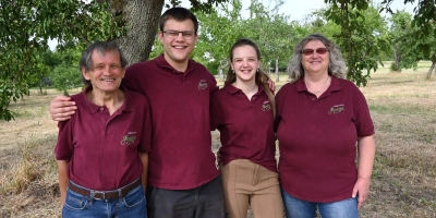 Walter Henninger, Ruben Henninger, Lea-Sofia Henninger und Karola Henninger (von links) stehen unter einem ihrer zwei 200 Jahre alten Birnbäume. Er trägt immer noch Früchte, die sich fürs Brennen eignen. (Foto: Anna Beigel)