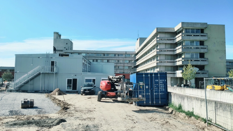 Über die Container links im Bild wird man ab Mitte des Jahres ins Krankenhaus in Ansbach kommen. Der B-Trakt (rechts im Bild) wird abgerissen und durch einen Neubau ersetzt.  (Foto: Robert Maurer)