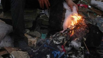 Der Palästinenser Mohammed al-Jabri, 58, wärmt sich neben einem Feuer, während er auf den Trümmern eines Gebäudes sitzt, das während der israelischen Luft- und Bodenoperationen im Viertel Sheikh Radwan zerstört wurden. (Foto: Abdel Kareem Hana/AP/dpa)