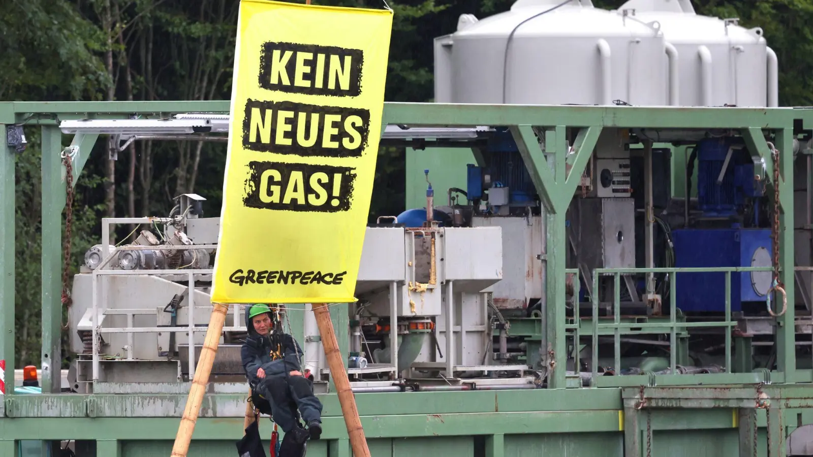Die Umweltorganisation Greenpeace protestiert gegen die geplante Gasbohrung in Reichling. Ein Umweltschützer hängt an einem Bambusgerüst. (Foto: Karl-Josef Hildenbrand/dpa)