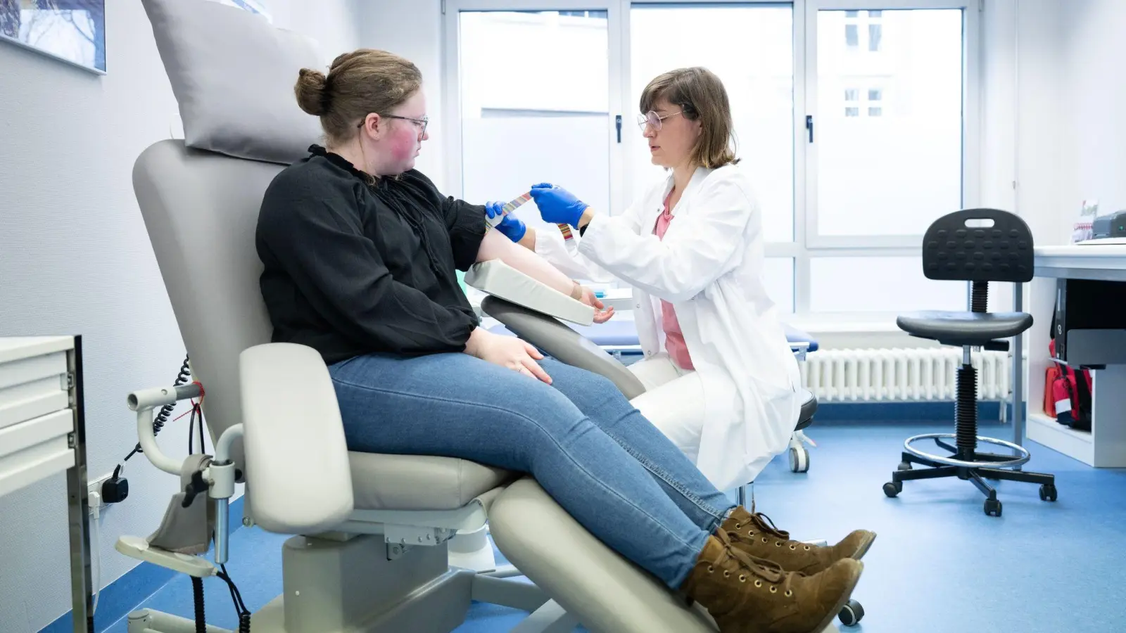 Katharina Egger-Heidrich (r), Fachärztin Onkologie, bereitet die Patientin Michelle Müller im Nationalen Centrum für Tumorerkrankungen am Universitätsklinikum auf eine Blutabnahme vor. (Foto: Sebastian Kahnert/dpa)