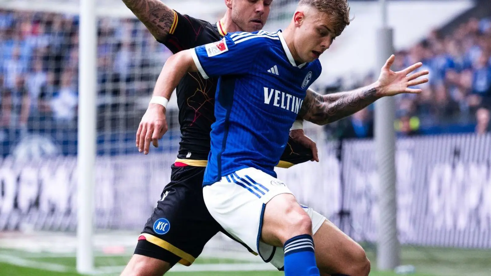 Schalkes Keke Topp (r) und Karlsruhes Marcel Franke kämpfen um den Ball. (Foto: Marius Becker/dpa)