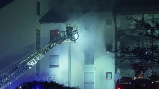 Feuerwehrleute sind bei einem Brand in einem Mehrfamilienwohnhaus in Bayern im Einsatz. (Foto: Dominik Bartl/dpa)