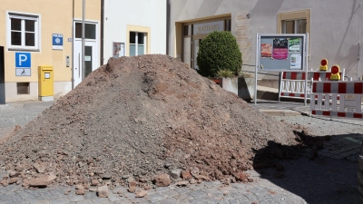In etwa in dem Bereich des aktuellen Erdhaufens wird künftig ein Wasserspiel sprudeln. Dort, wo bislang Trogpflanzen dem Rathauszugang einen grünen Tupfer verschaffen, soll der wasserspeiende Drache positioniert werden, der einst in der Adi-Dassler-Straße stand und aktuell zur Auffrischung in einem Markt Bibarter Betrieb schlummert. (Foto: Andreas Reum)