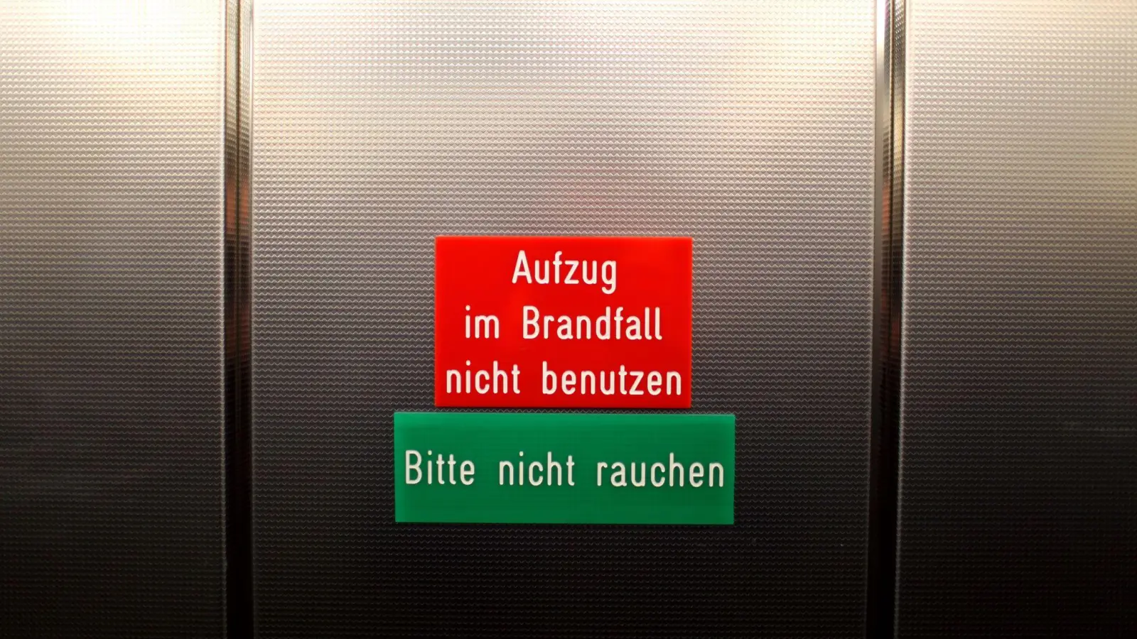 Hinweisschilder in einem Aufzug. (Foto: picture alliance / dpa)