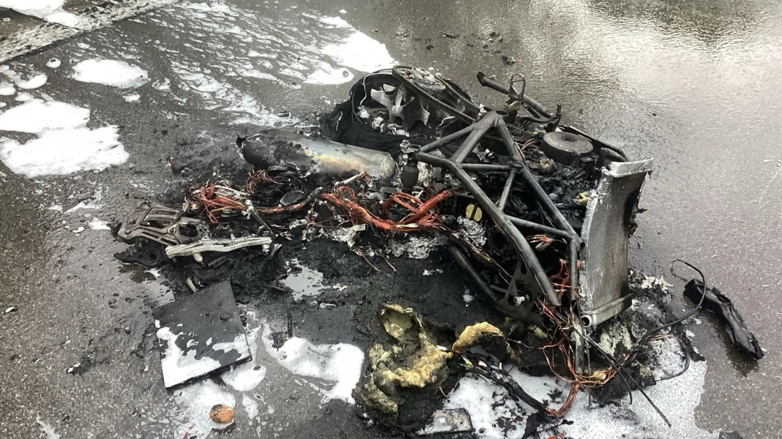 Nur noch ein Trümmerhaufen: Wrackteile eines ausgebrannten Motorrads auf der A95 (Foto: -/Feuerwehr München/dpa)