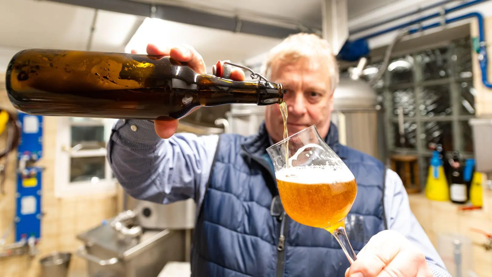 Kai Beitzer kontrolliert sein selbstgebrautes Bier. Er braut Bier in einem alten Schlachtraum. (Foto: Philipp Schulze/dpa)